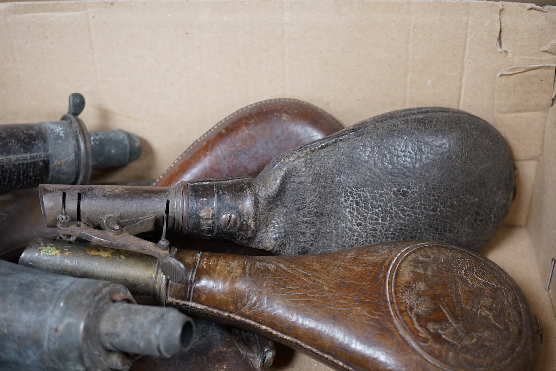 Three gun-sized copper powder flasks, two of which are embossed, together with four leather shot bags each with sprung chargers, two iron and two brass examples, one of which is embossed with a hunting scene (7)